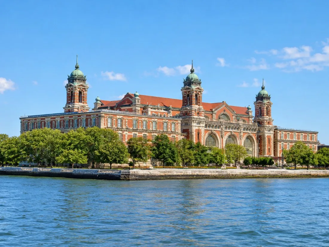 The red-brick Main Building of Ellis Island with its copper-domed towers, seen from the water